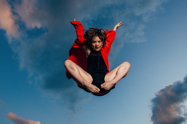 Щаслива усміхнена спортивна молода жінка стрибає в повітрі під час танців
 - Фото, зображення