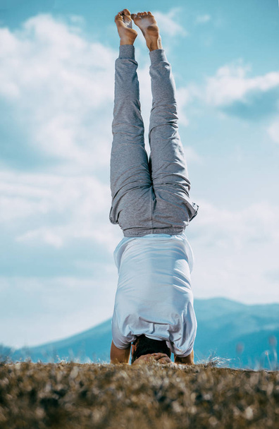 Yoga practice exercise class concept. Young man doing exercise. Young man practicing yoga at mountain. - Foto, Imagen