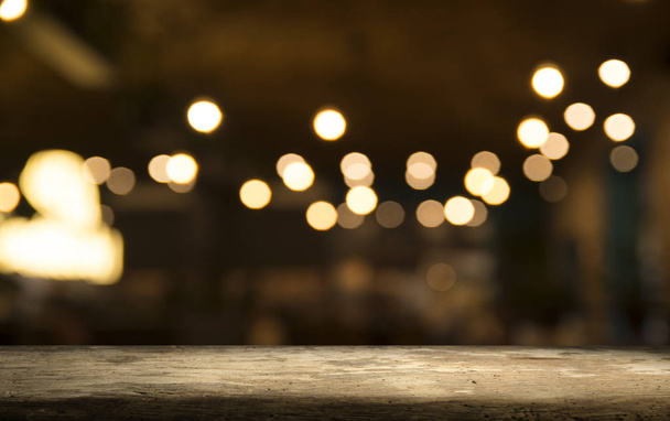 Empty wood table top on blur light gold bokeh of cafe restaurant in dark background - Photo, Image
