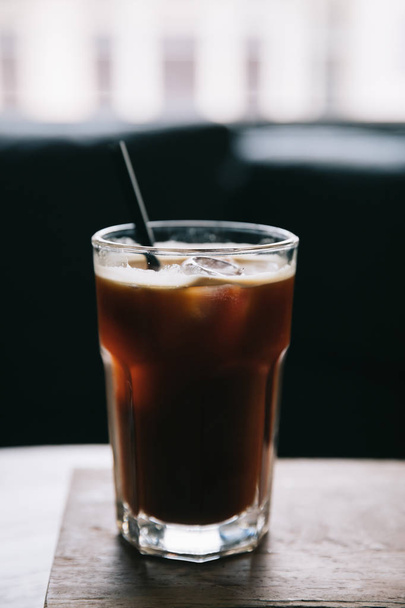 Iced coffee in a tall glass at coffee shop - Zdjęcie, obraz