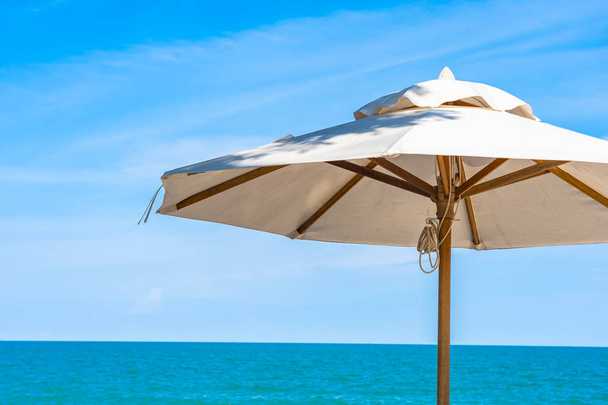 Gyönyörű napernyő és szék körül strand tengeri óceán kék sk - Fotó, kép