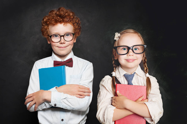 Clevere Kinder mit Brille und Schuluniform halten Bücher in der Hand - Foto, Bild