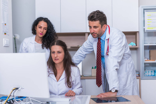 Twee verpleegkundigen (vrouwelijke artsen) en een mannelijke arts die naast elkaar staan - Foto, afbeelding