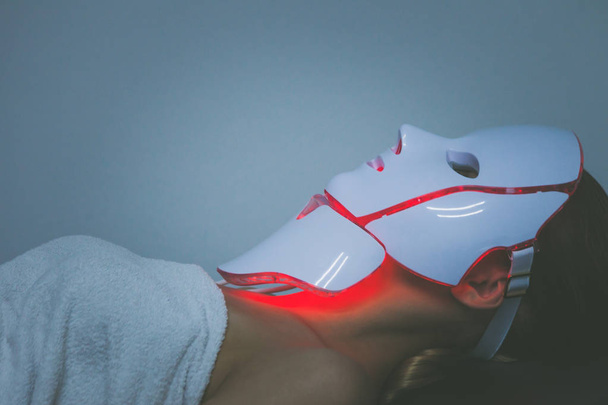 woman  with led light therapy facial and neck  beauty mask photo - Foto, Bild