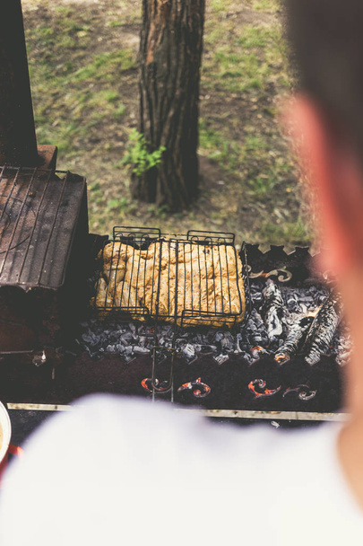 Man Fries marynowane kurczaka na metalowej siatce - Zdjęcie, obraz