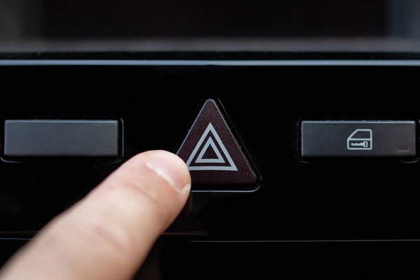 Mão pronta para pressionar o botão de aviso de um carro, Botão desligado
 - Foto, Imagem