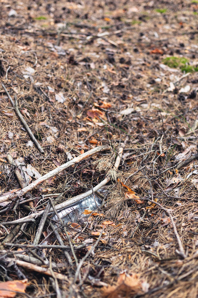 Белая пластиковая бутылка на земле в сосновом лесу
. - Фото, изображение