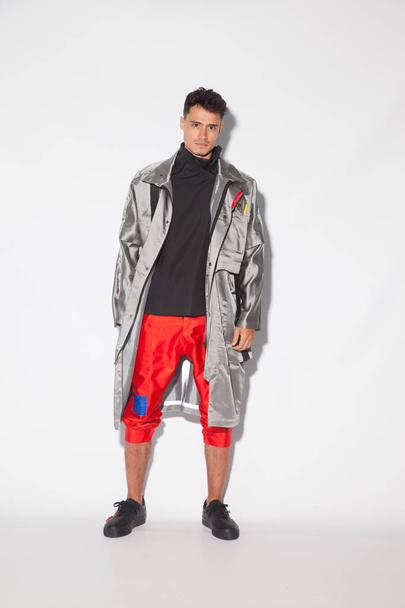 Handsome, sexy young guy with futuristic modern clothes, urban designer clothes on white background - Valokuva, kuva