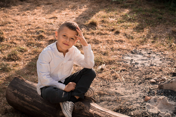 adolescente menino senta-se em um log
 - Foto, Imagem