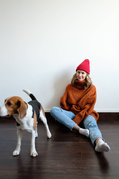 Girl in a sweater at home plays with a dog - Fotó, kép