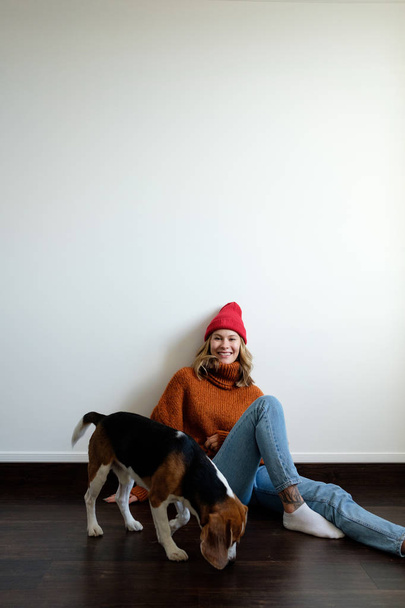 Girl in a sweater at home plays with a dog - Foto, Imagen
