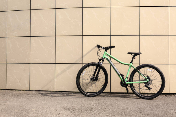 屋外のベージュの壁の近くに近代的な自転車。テキスト用のスペース - 写真・画像