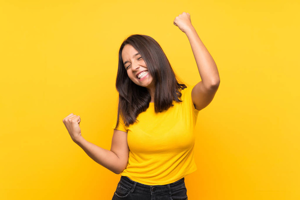 Young brunette girl over isolated background celebrating a victory - Фото, изображение