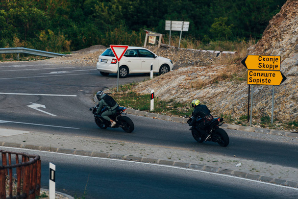 Motorcyclists on mountainous road, enjoying tour along summertime activities, wonderful mountai - Fotoğraf, Görsel