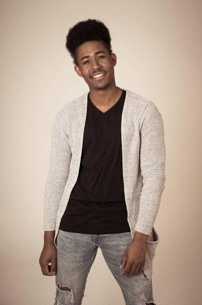 Portrait of attractive stylish young african american teenager man posing happy looking at the camera with fashion and stylish clothes and afro hairstyle. In People beauty and youth fashion trends. - Foto, immagini