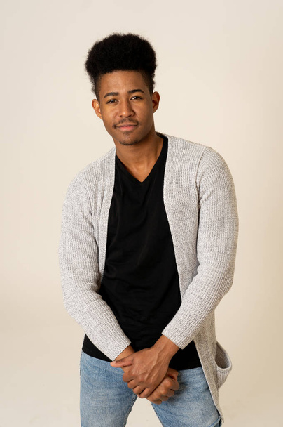 Portrait of attractive stylish young african american teenager man posing happy looking at the camera with fashion and stylish clothes and afro hairstyle. In People beauty and youth fashion trends. - Valokuva, kuva
