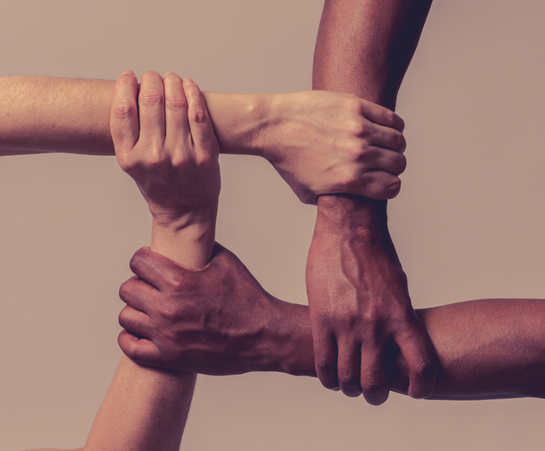 Races united against discrimination and racism. Black African American and Caucasian hands holding together in world unity and racial love and understanding. Tolerance and cooperation concept. - Photo, image