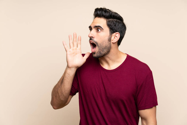 Handsome young man over isolated background shouting with mouth wide open - Photo, Image