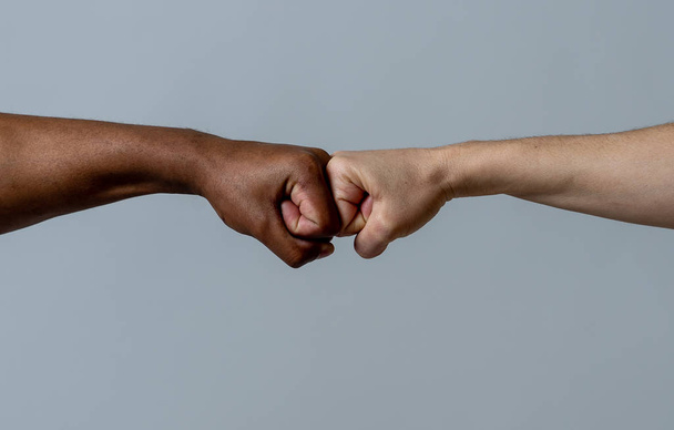 Black African American race male and white Caucasian woman hands giving a fist bump in agreement partnership and cooperation multiracial diversity and immigration concept. Stop racism campaign. - Valokuva, kuva