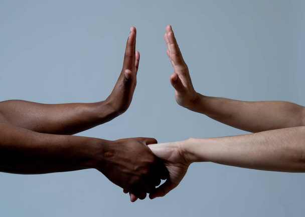 Black African American and Caucasian hands holding together. Conceptual image of Races coming together in world unity and stop racism. In racial tolerance understanding and cooperation concept - Foto, imagen