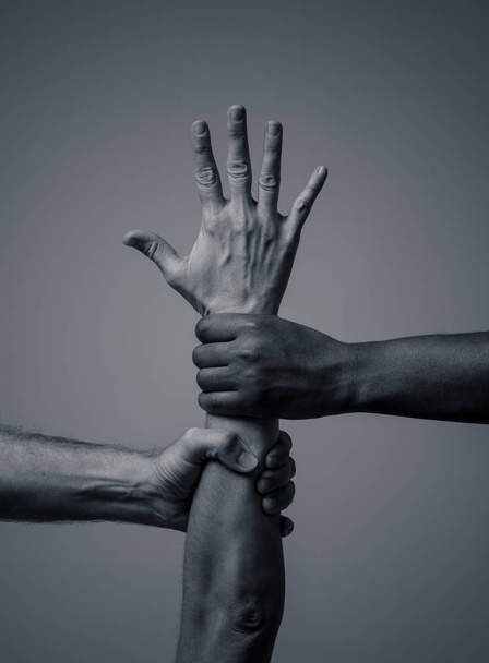 Black African American and Caucasian hands holding together. White and black skin arms in world united against racism, racial love and understanding races diversity and Human rights cooperation concept - Fotó, kép