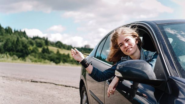 Happy woman travels by car in the mountains. Summer vacation concept - Foto, immagini
