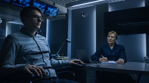 Female Special Agent Conducts Lie Detector / Polygraph Test on a Young Suspect. Expert Examiner Questions Accused in Interrogation Room. Computer Measures Physiological indices. - Zdjęcie, obraz