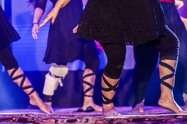 pieds d'un danseur sur scène faisant position de danse hip hop avec des lumières au néon de fond
 - Photo, image
