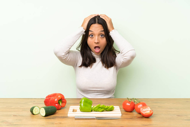 Young brunette woman with vegetables with surprise facial expression - Photo, Image