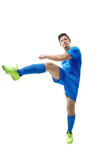 Asian football player man in the pose of kicking the ball - Фото, изображение