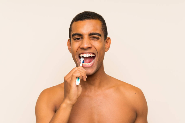 Young handsome brunette man brushing his teeth - Фото, изображение