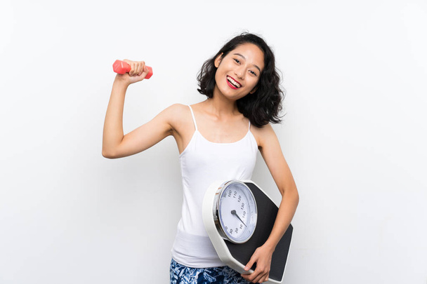 Joven chica asiática haciendo levantamiento de pesas y con máquina de pesaje
 - Foto, imagen