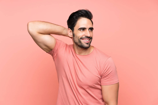 Handsome young man over isolated pink background laughing - Фото, зображення