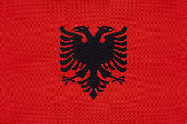 アルバニア国立ファブリックフラグテキスタイルの背景。国際世界バルカンヨーロッパ諸国のシンボル. - 写真・画像