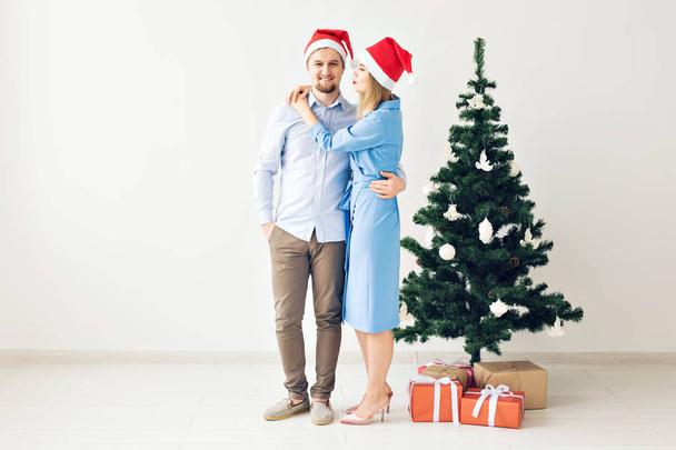 Vacanze invernali e concetto di famiglia - Felice giovane coppia vicino all'albero di Natale a casa
 - Foto, immagini