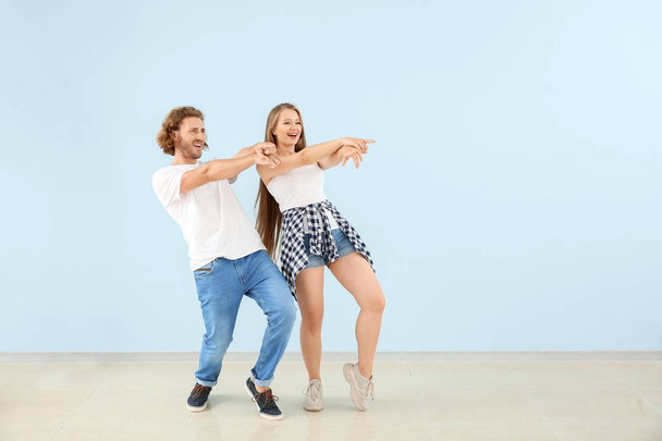 Cool jeune couple dansant contre le mur de couleur
 - Photo, image