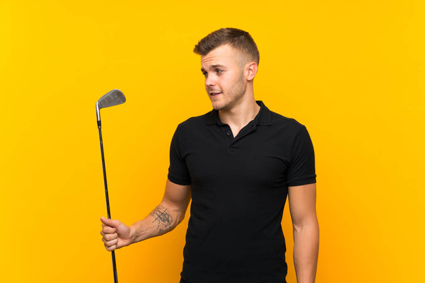 Golfer player man over isolated yellow background with happy expression - Фото, изображение