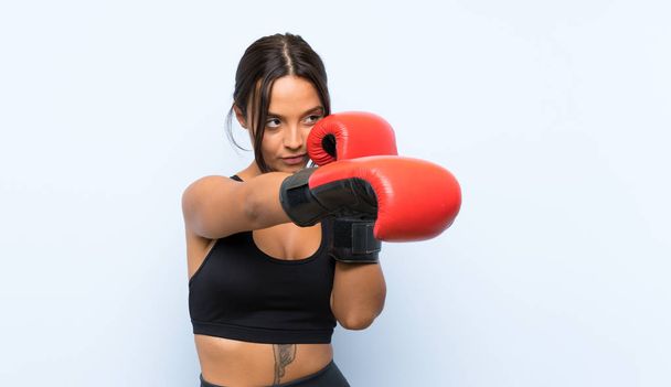 Young sport girl with boxing gloves over isolated blue background - Photo, Image