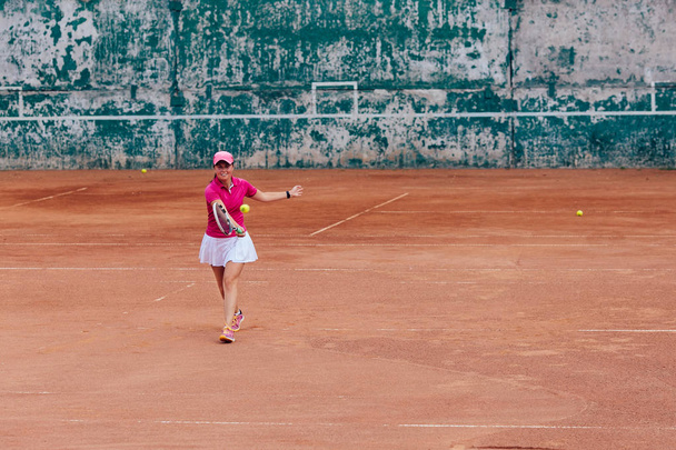 Tennis player. Charming female tennis player taking receive serve. Dressed in stylish sportswear. Outdoors. - Фото, изображение