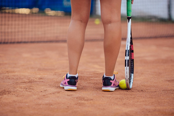 Close-up women's legs with racket and ball during a match game. - Foto, Bild