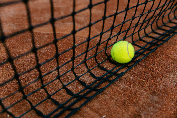 Close-up tennis ball in net on the court. - Zdjęcie, obraz