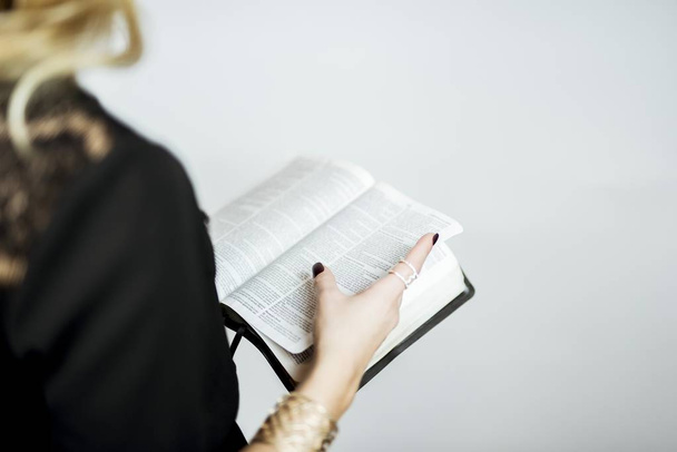 A selective closeup shot of a person reading a book - Fotó, kép
