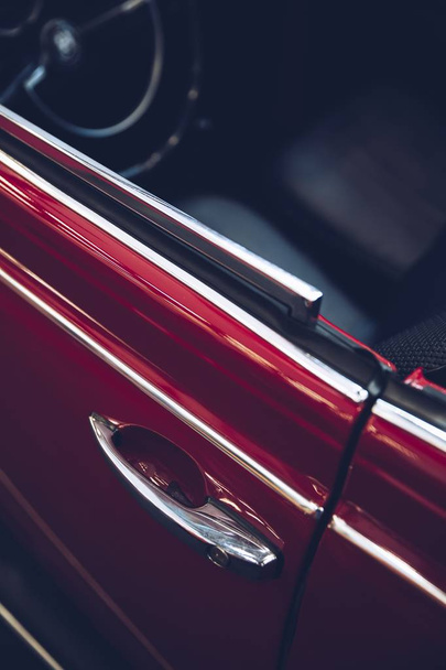 A closeup shot of a red car door with a blurry background - Zdjęcie, obraz