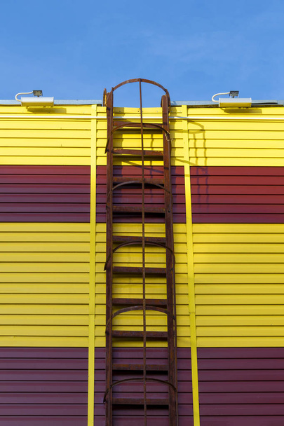 Staircase to the roof of a transformer substation.  Two-tone facade of the building.  Front view. - 写真・画像