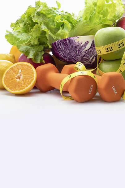 Fresh fruits, vegetables, weights and measuring tape on white background. - Foto, Bild