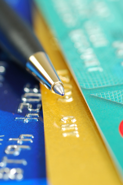 Una pluma en la parte superior de varias tarjetas de crédito
 - Foto, imagen