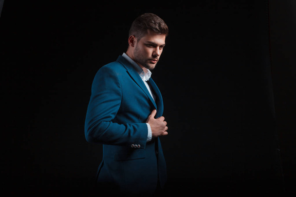 handsome man wearing suit posing on black background in studio - Photo, Image