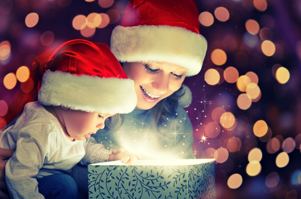 Caja de regalo mágica de Navidad y una feliz madre y bebé de la familia
 - Foto, imagen