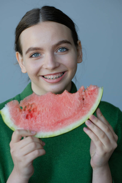young woman eating sweet watermelon slice in home interior - Photo, Image