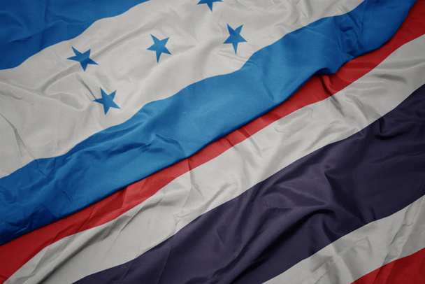 размахивая красочным флагом Таиланда и национальным флагом Гондураса
. - Фото, изображение